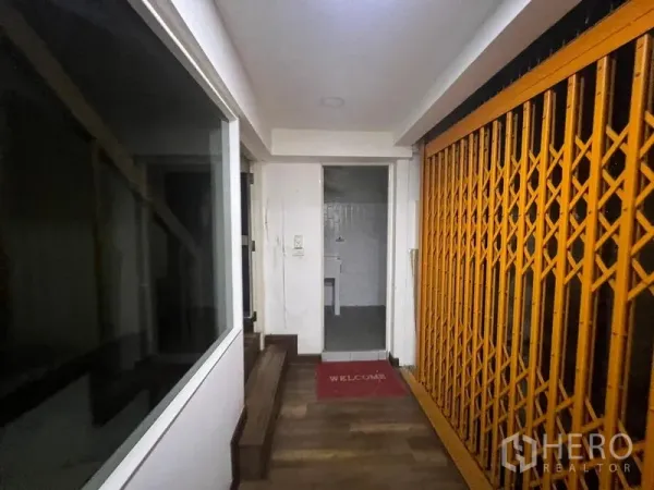 店屋 出租或出售在Watthana, Bangkok - 室内走廊，配黄色折叠护栏门、台阶及小型卫生间入口。