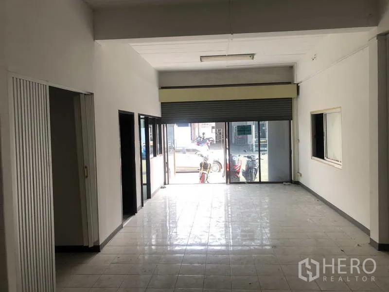 Factory for rent in Khlong Luang, Pathum Thani - Front entrance with sliding glass doors and rolling shutter opening to the street.