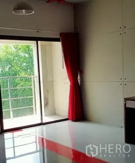 Office Space for rent in Khlong Toei, Bangkok - Office corner with sliding door opening to a small balcony overlooking greenery.