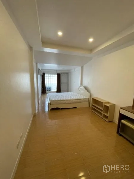Townhouse for rent in Phra Khanong, Bangkok - Large master bedroom with bed, glass-block wall and natural light.