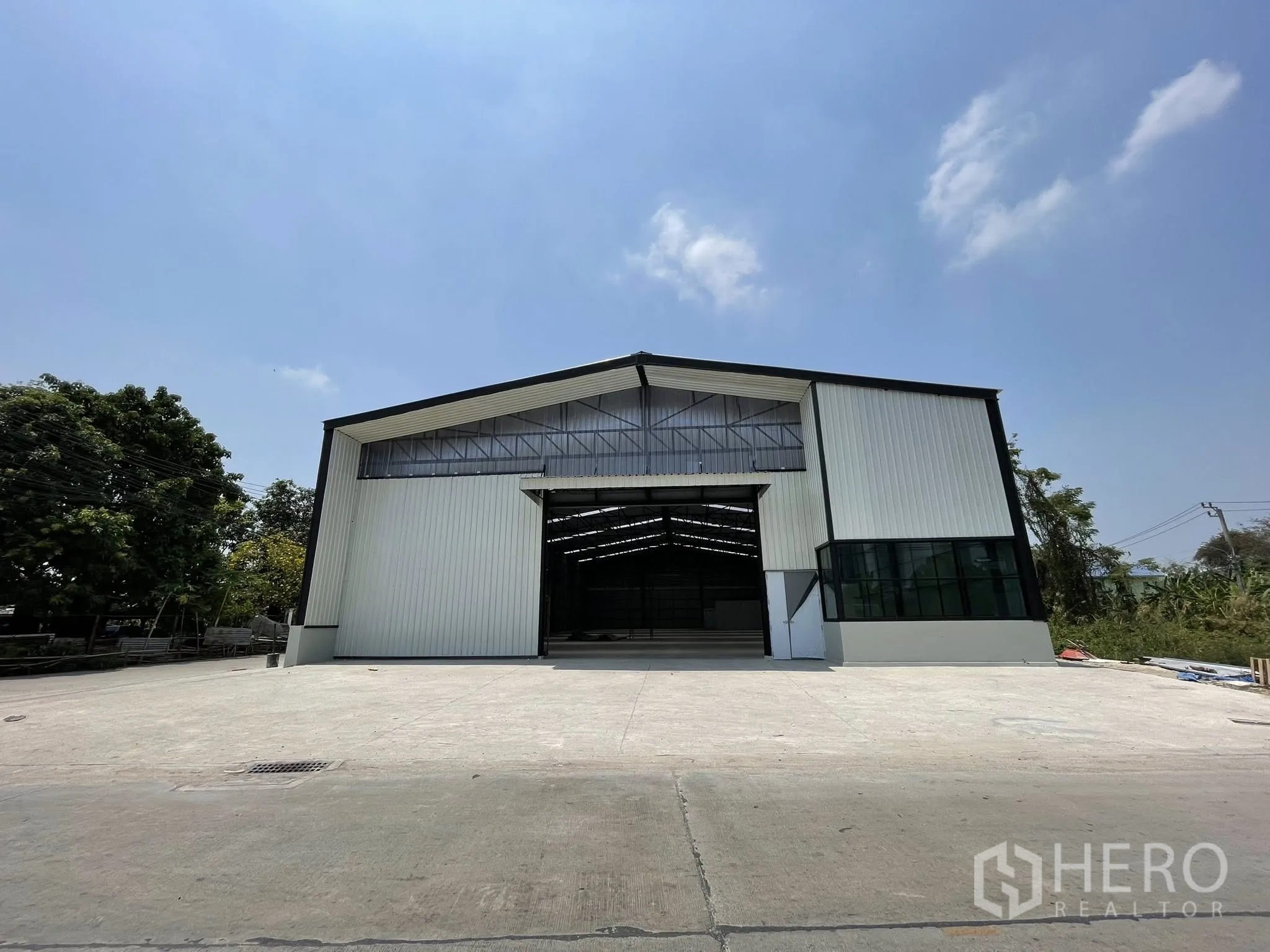 仓库 for rent in Pak Kret, Nonthaburi - 正面全景，仓库与宽大混凝土前场。
