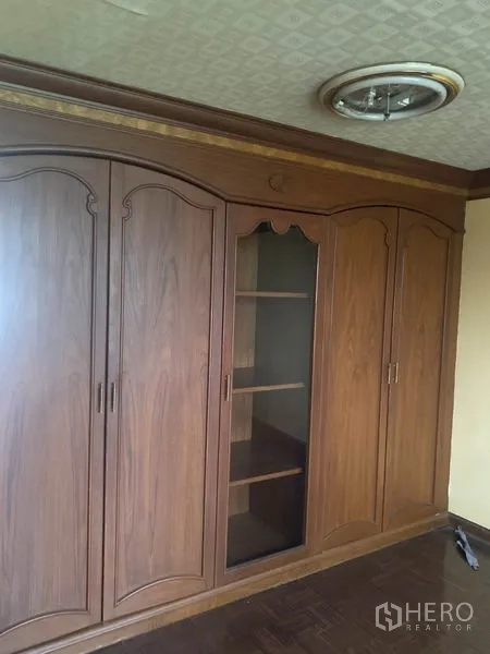 Shophouse for rent in Watthana, Bangkok - Built-in wooden wardrobes with central shelving and a decorative ceiling light