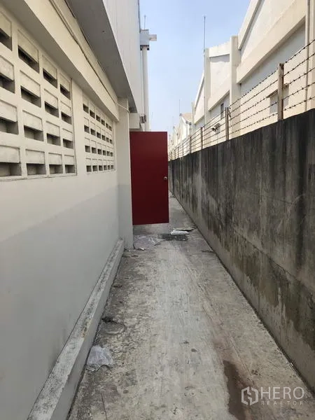 工厂 出租在Khlong Luang, Pathum Thani - 后方服务通道，红色安全门与围墙