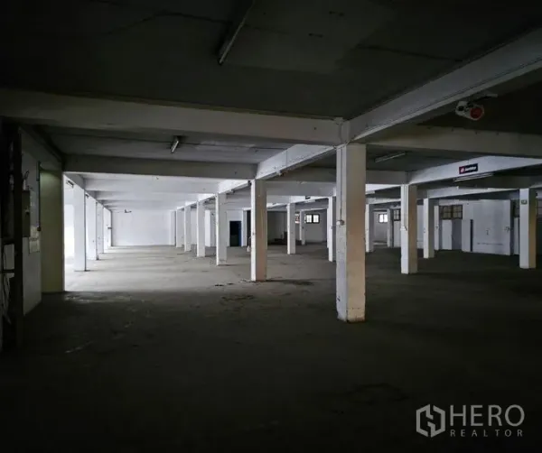 Factory for rent in Bang Kho Laem, Bangkok - Expansive factory floor with concrete columns and strip lighting.