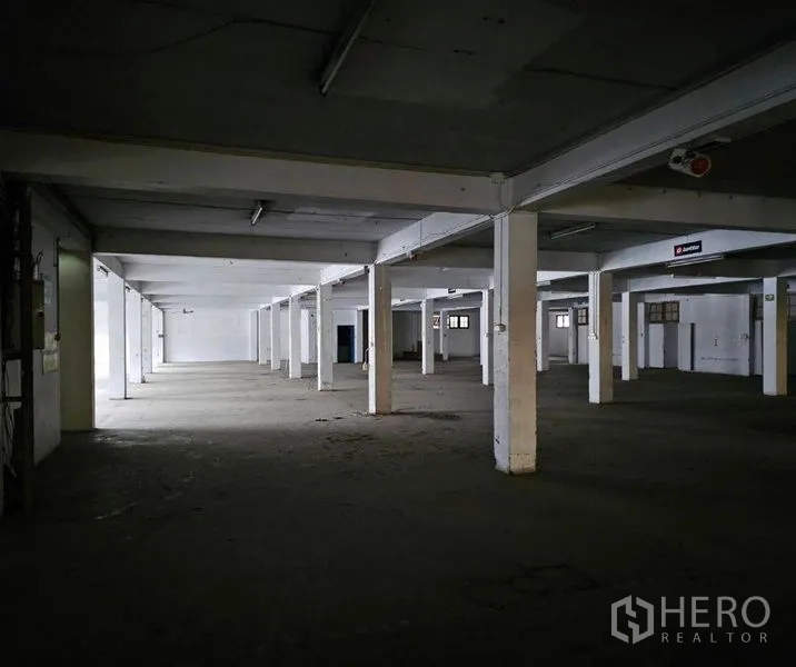 Factory for rent in Bang Kho Laem, Bangkok - Expansive factory floor with concrete columns and strip lighting.