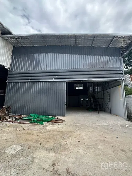 Warehouse for rent in Suan Luang, Bangkok - Steel-clad warehouse exterior with wide opening, covered loading bay and a concrete forecourt.