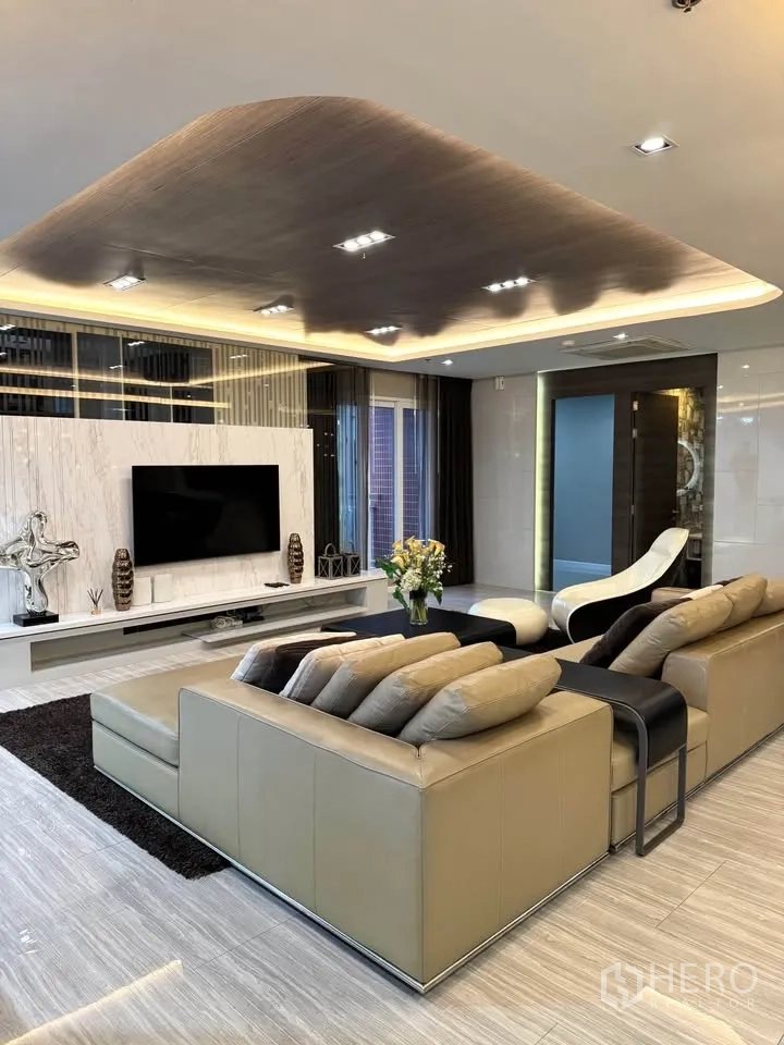 Condominium for rent or sale in Khlong Toei, Bangkok - Feature TV wall with marble finish, sectional sofa and ambient cove lighting.