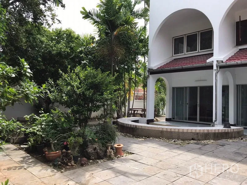 独立式住宅 出租在Phra Khanong, Bangkok - 房屋后立面设拱形露台、推拉玻璃门与景观花园。