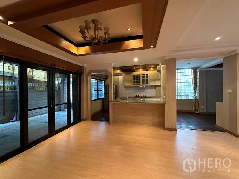 Townhouse for rent in Khlong Toei, Bangkok - Open dining and kitchen area with tray ceiling, chandelier and sliding doors to the terrace.