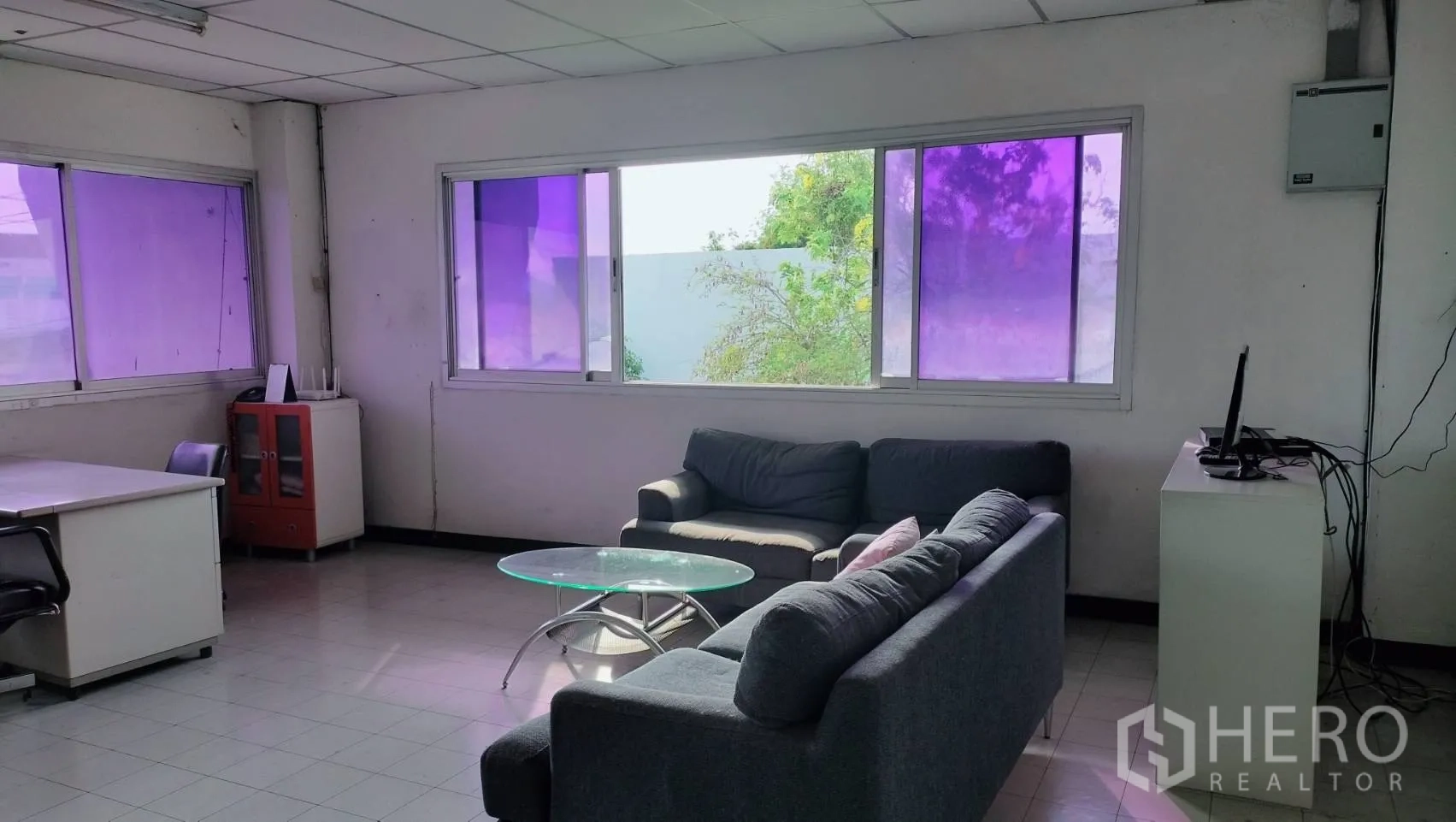 Factory for rent in Lat Krabang, Bangkok - Furnished office lounge with sofas and a glass coffee table beside large windows.