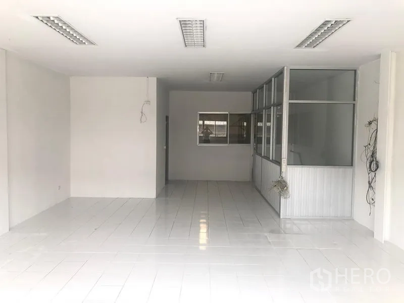 Factory for rent in Khlong Luang, Pathum Thani - Bright tiled office area with glass-partitioned meeting room.