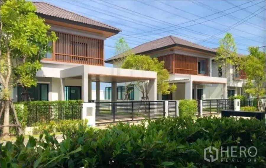 Detached House for sale in Bang Phli, Samut Prakan - Street view of gated modern detached homes with landscaped hedges