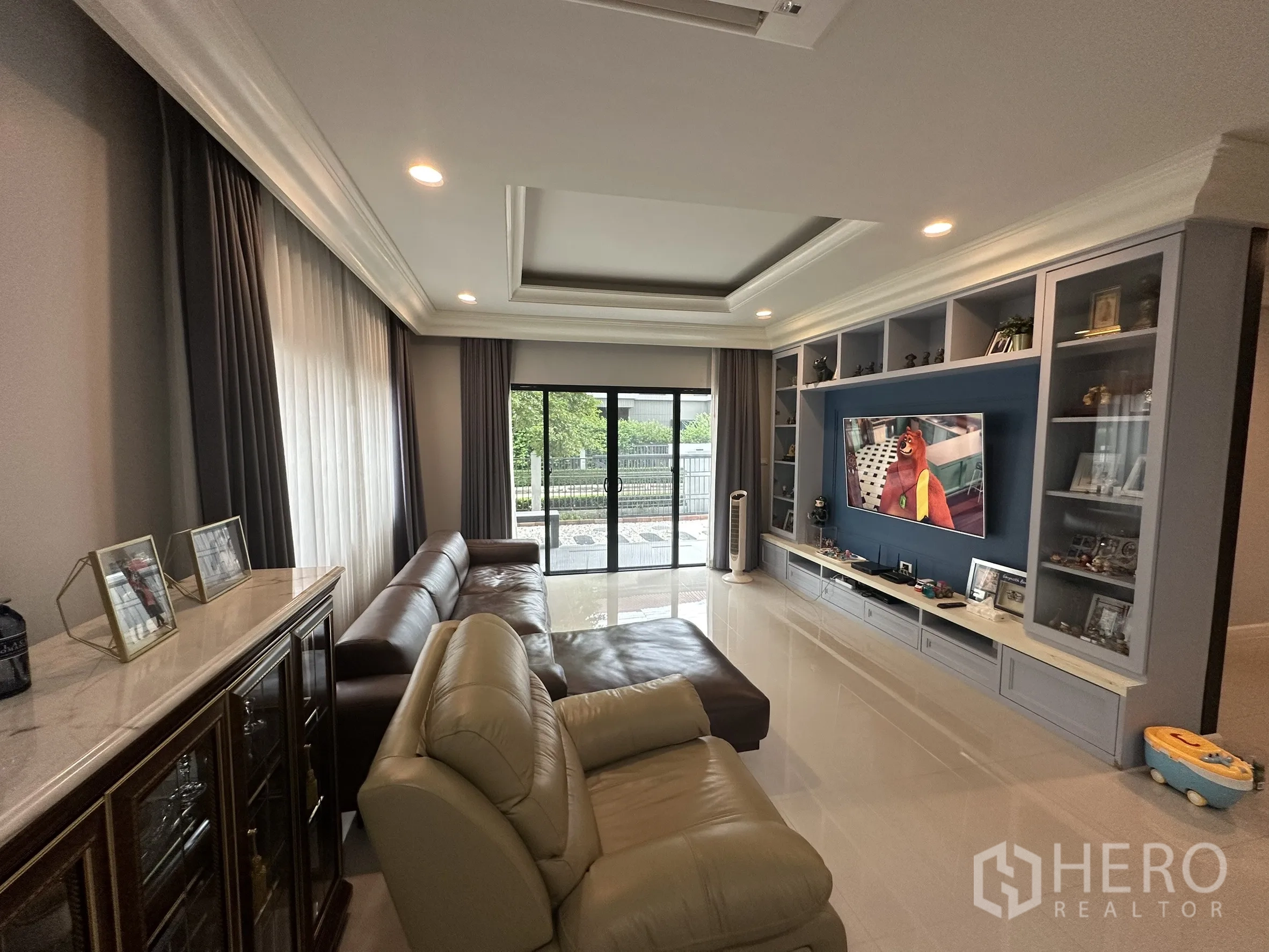 Detached House for rent in Lam Luk Ka, Pathum Thani - Living room view toward garden with large sliding glass doors.