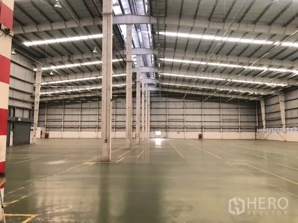 Factory for rent in Phra Nakhon Si Ayutthaya - Spacious factory floor with high steel roof, skylights and marked lanes for production and storage.