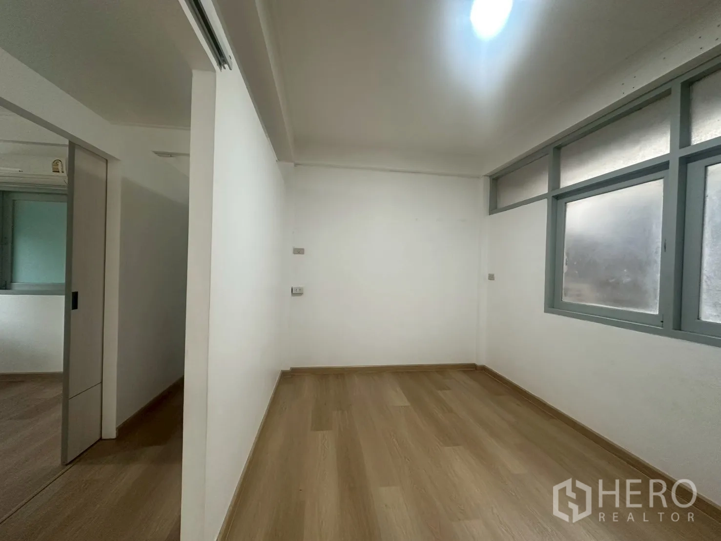 Detached House for rent in Watthana, Bangkok - Small room with frosted windows and light wood flooring adjoining a corridor.