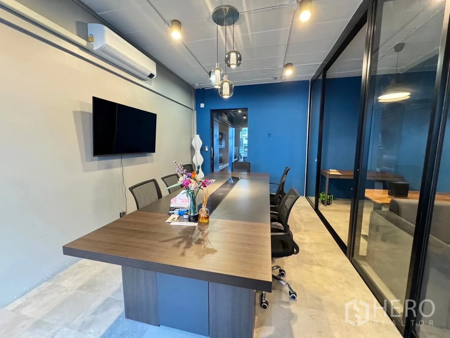 Home Office for rent in Watthana, Bangkok - Conference room view showing air-conditioning, TV screen and seating.