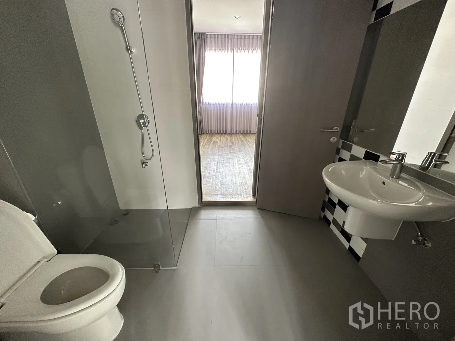Home Office for rent or sale in Suan Luang, Bangkok - Bathroom with glass shower screen, pedestal sink and checkered accent tiles.