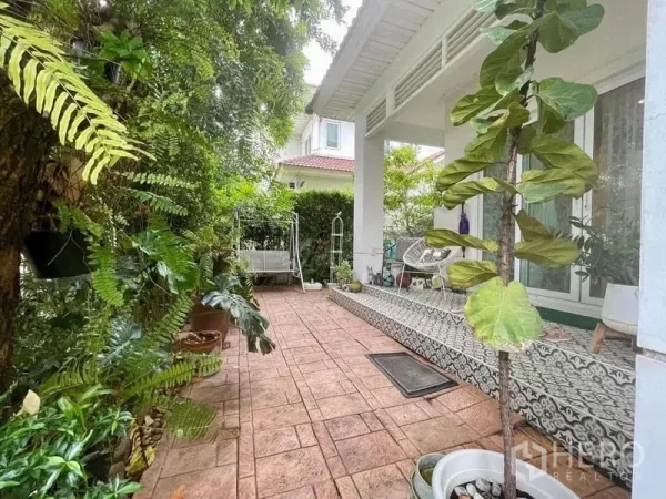 Detached House for rent - Shaded patio beside the house with patterned steps and lush tropical garden and swing seat.