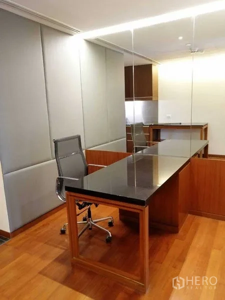 Condominium for rent in Pathum Wan, Bangkok - Dedicated work corner with long black stone desk, task chair and mirrored wall.