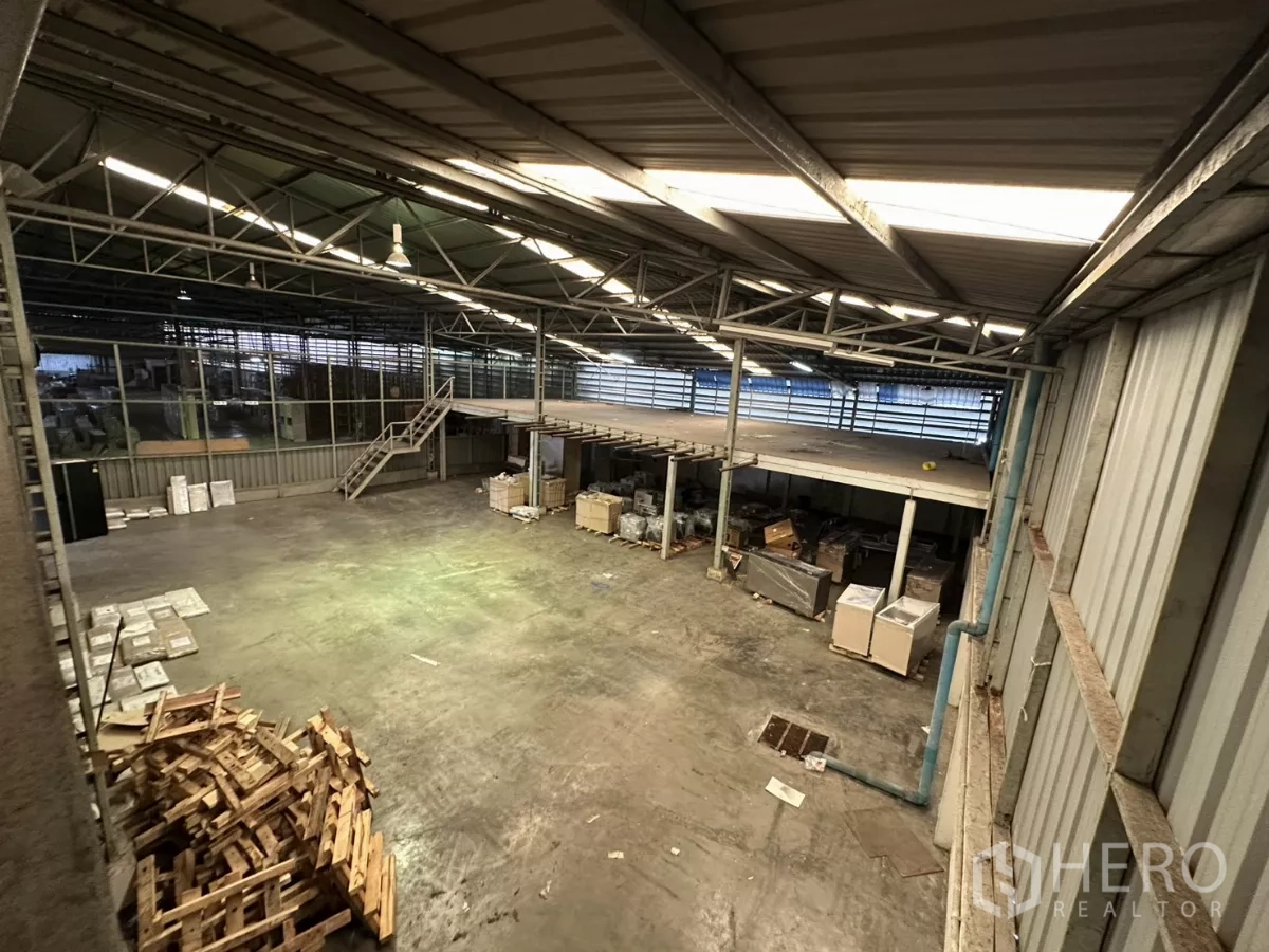 Warehouse for rent in Yan Nawa, Bangkok - High view of open warehouse floor and mezzanine beneath a steel truss roof.