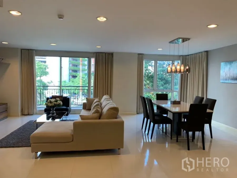 Condominium for rent in Khlong Toei, Bangkok - Open-plan living room with sofa set, dining table and balcony access.