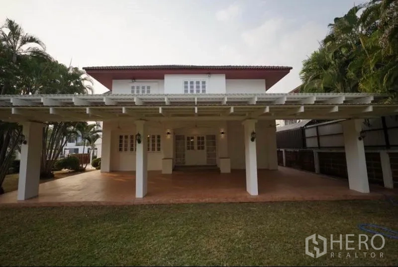 Detached House for rent in Bang Phli, Samut Prakan - Covered rear terrace with pergola opening to a large lawn and mature trees.