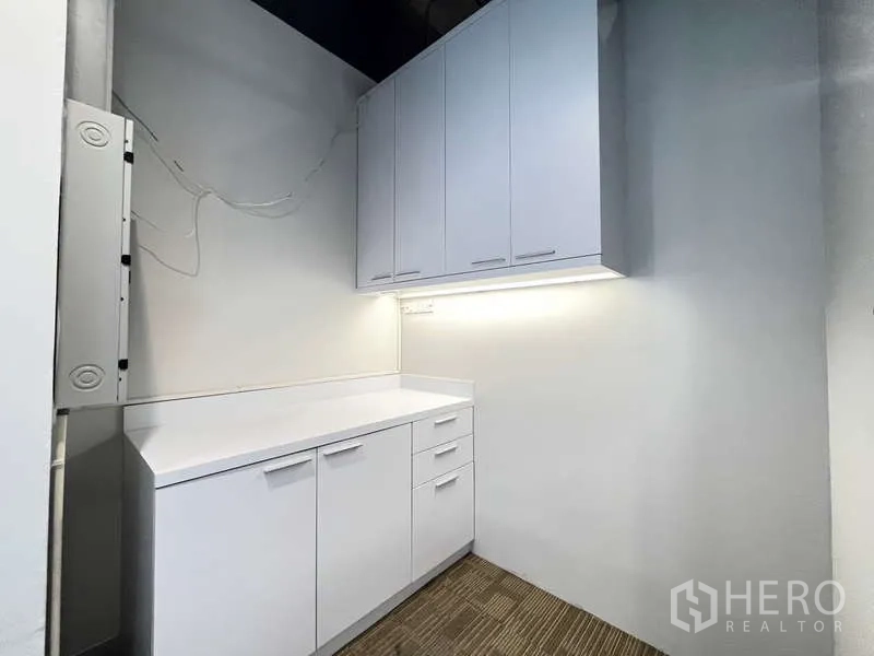 Office Space for rent in Watthana, Bangkok - Pantry corridor with two counter sections, overhead cupboards and door to service area.