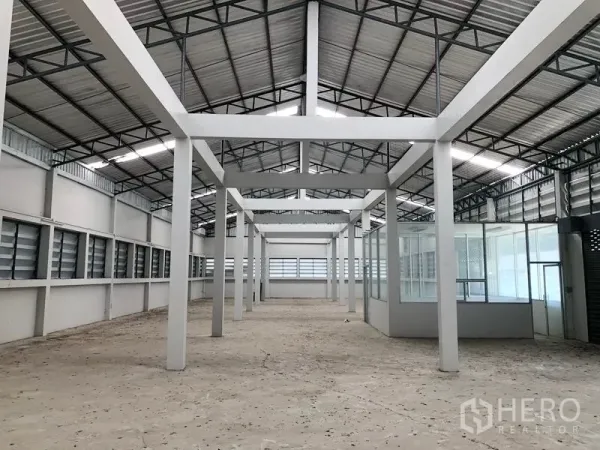 Factory for rent in Bang Bua Thong, Nonthaburi - Spacious factory interior with high steel roof, white columns, and louvered ventilation windows.
