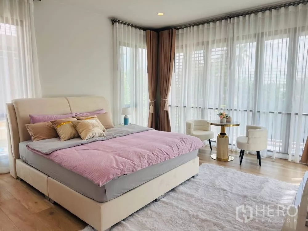 Detached House for rent or sale in Bang Kapi, Bangkok - Spacious master bedroom with corner windows, seating set and plush rug.