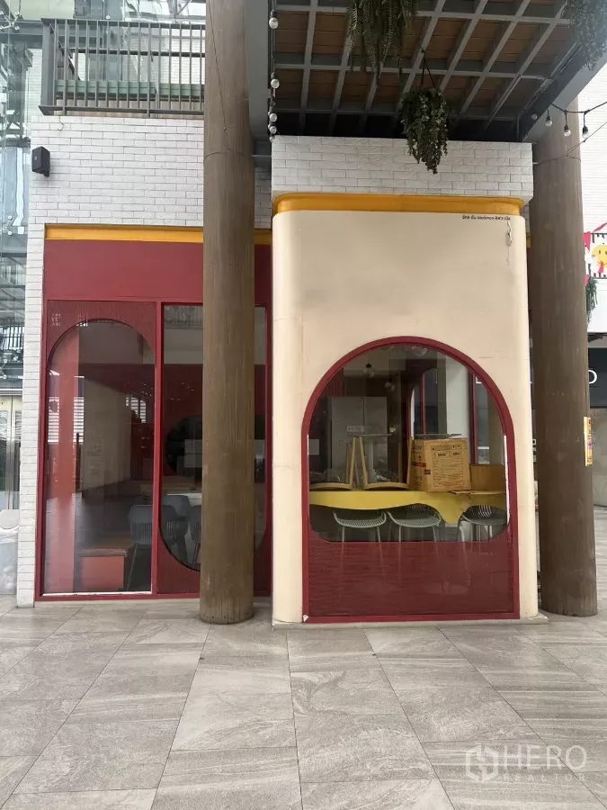 Retail Space for rent in Khlong Toei, Bangkok - Street-level retail unit with red arched windows and tall timber columns in a covered atrium.