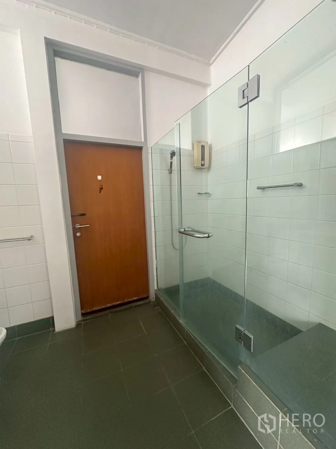Detached House for rent in Watthana, Bangkok - Bathroom with glass-enclosed shower, tiled walls and grey floor.