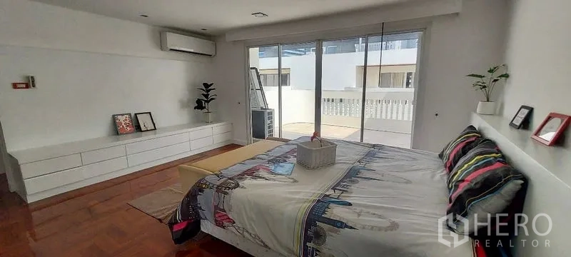 Townhouse for rent in Sathon, Bangkok - Master bedroom with balcony access, long built-in cabinet and air conditioner.