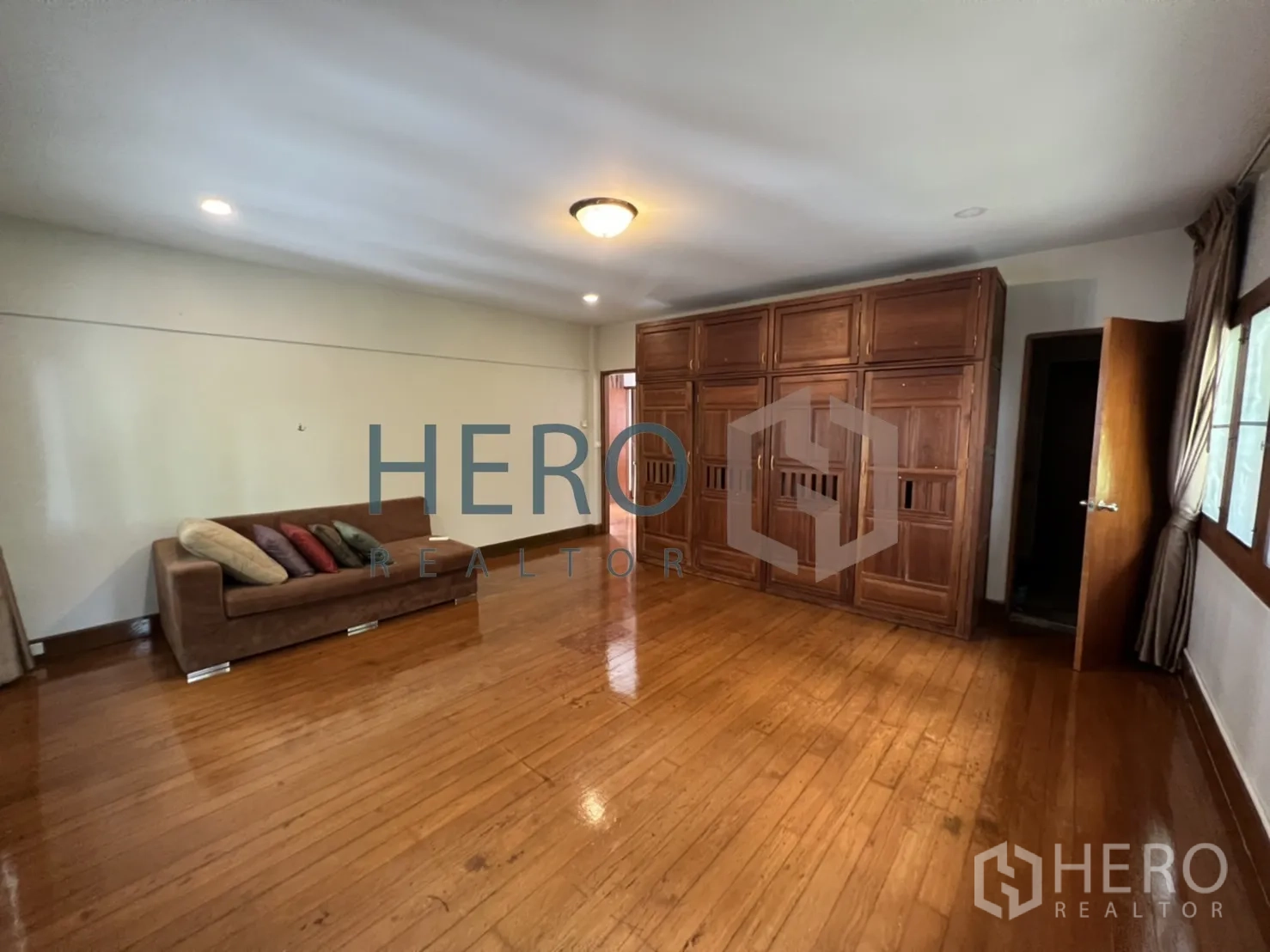 Detached House for rent in Watthana, Bangkok - Another view of the large bedroom with sofa and closets.