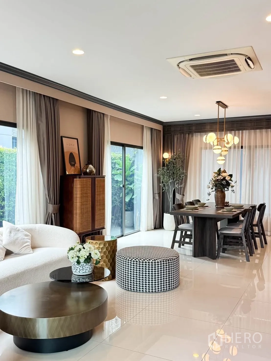 独栋房屋 for rent in Bang Kapi, Bangkok - 开放式客餐厅，配弧形沙发、圆形茶几、推拉落地窗与吊灯。