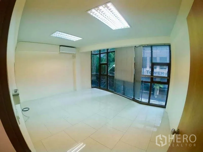 Office Space for rent in Khlong Toei, Bangkok - Bright office room with curved floor-to-ceiling windows, blinds and air-conditioning.