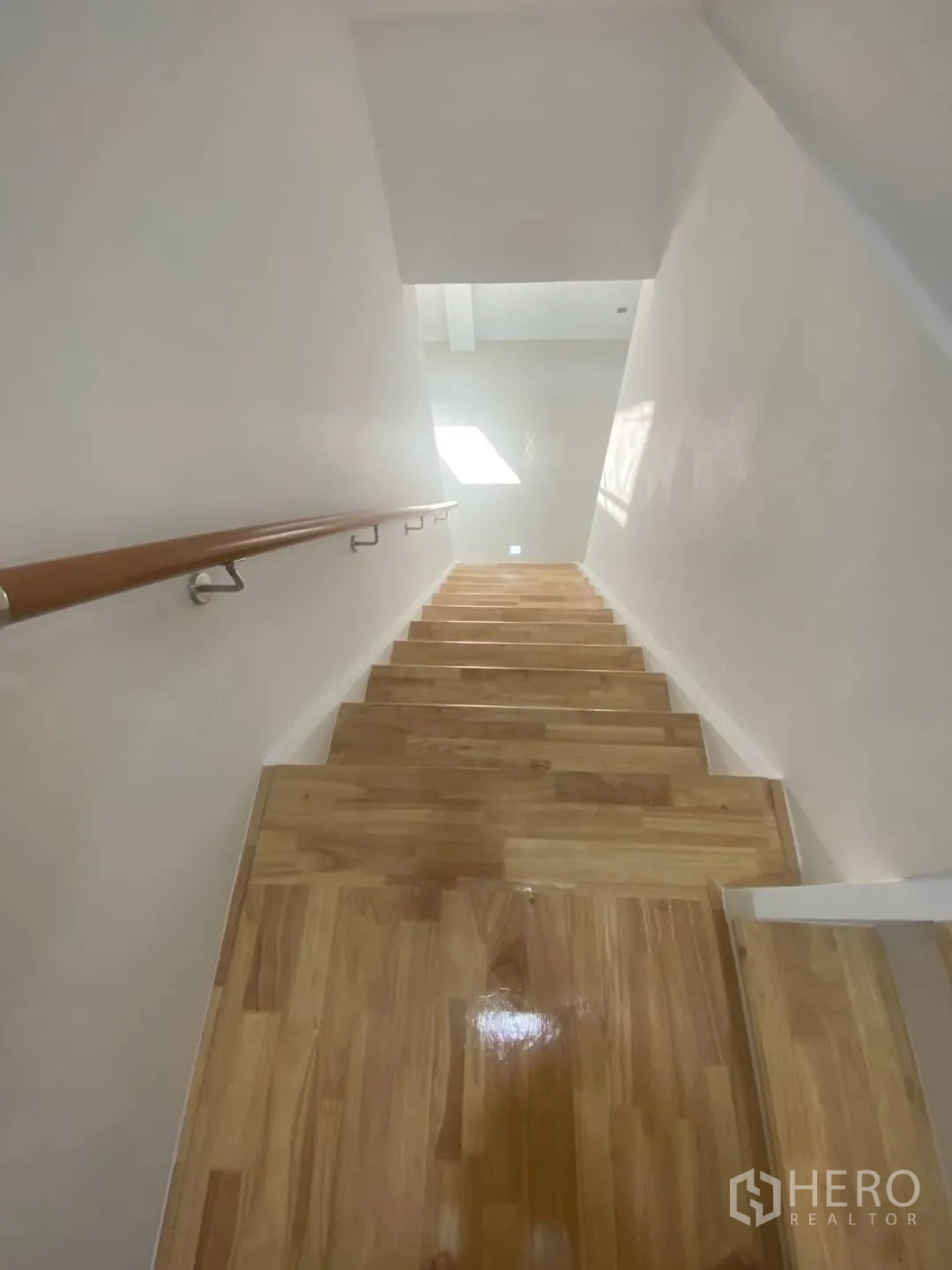 Home Office for sale - Timber staircase descending with sleek handrail and light-washed walls.