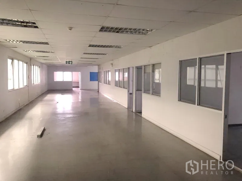 Factory for rent in Phra Nakhon Si Ayutthaya - Elongated office corridor with windows and multiple partitioned rooms for teams.