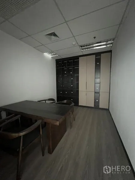 办公空间 出租在Huai Khwang, Bangkok - 小型会议室，深色木桌与整面储物柜。
