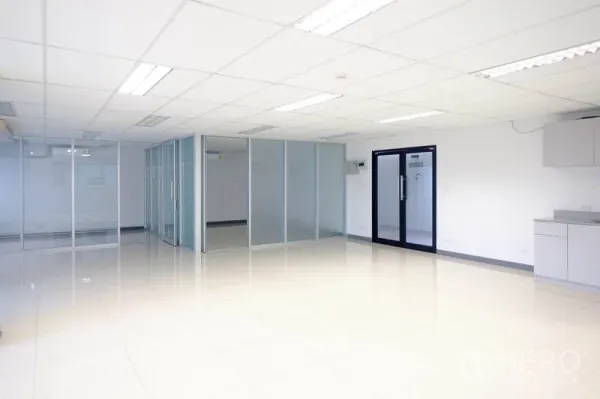 Office Space for rent in Chatuchak, Bangkok - Spacious office area featuring glass-partitioned rooms, black-framed door and a kitchenette.