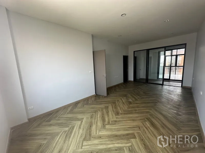 Home Office for rent - Large room with herringbone flooring and sliding glass doors to a balcony area.