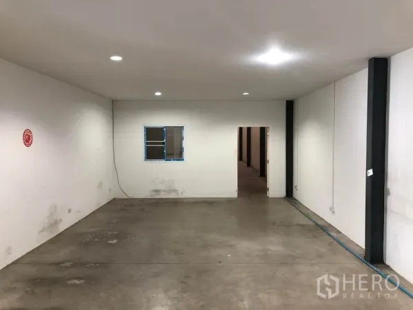 Warehouse for rent in Mueang Samut Prakan, Samut Prakan - Ground-floor office space with white walls, recessed lighting and concrete floor.