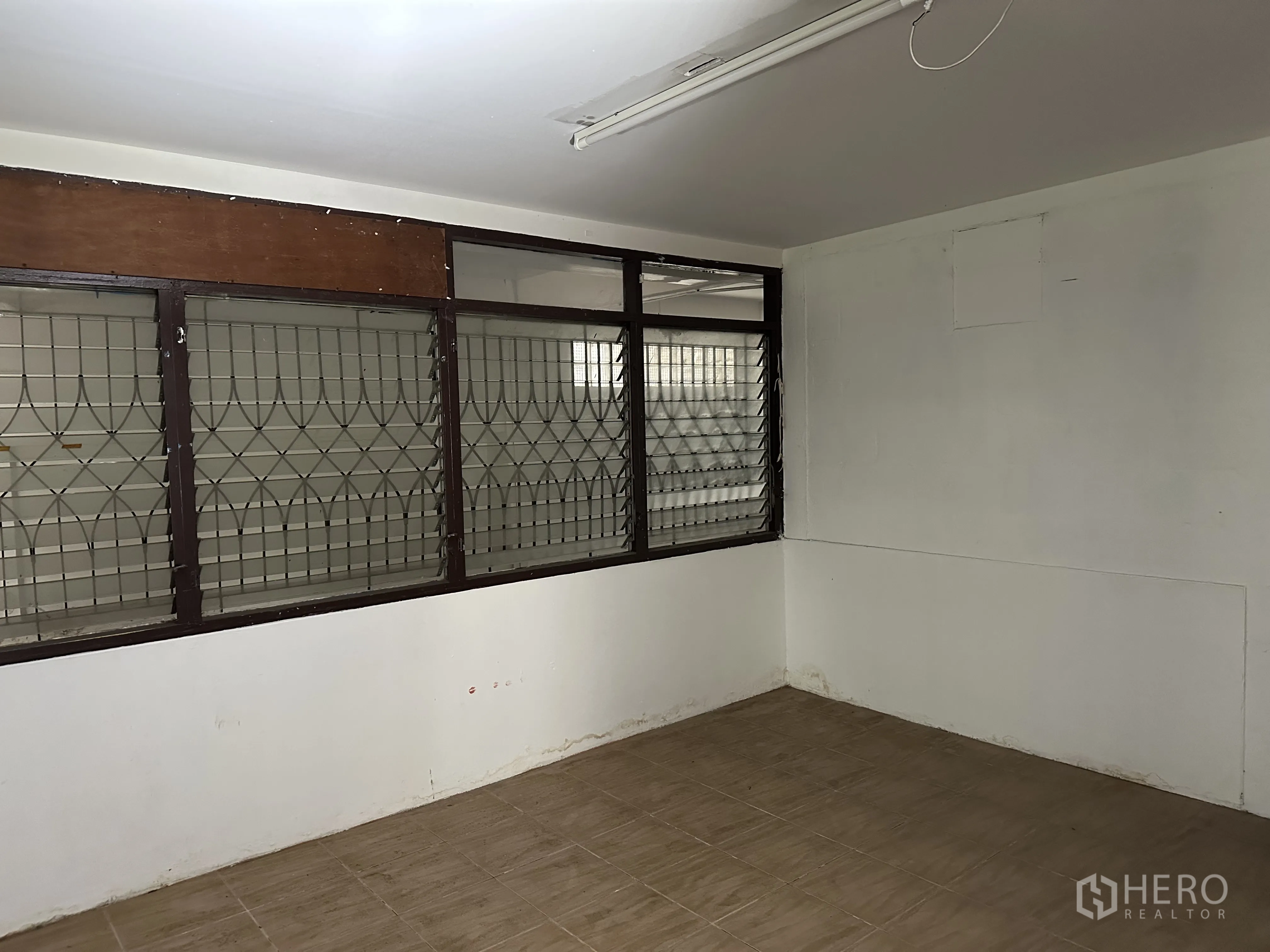 Home Office for rent in Suan Luang, Bangkok - Compact office room with tiled floor and barred windows.