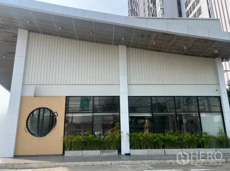 零售空间 出租在Watthana, Bangkok - 正立面现代设计，挑檐、圆形装饰窗与绿化花槽。