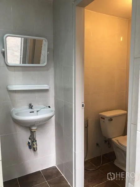 Factory for rent in Pak Kret, Nonthaburi - Compact washroom with sink and separate toilet cubicle.