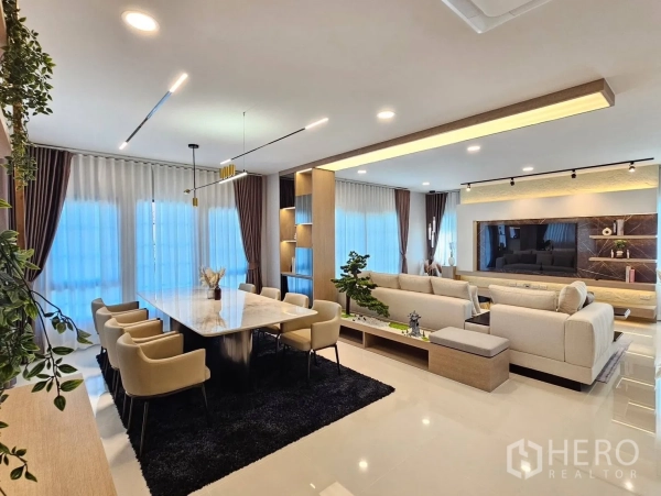 Detached House for rent or sale in Bang Phli, Samut Prakan - Open‑plan dining and living space with marble table, sofas and decorative lighting.