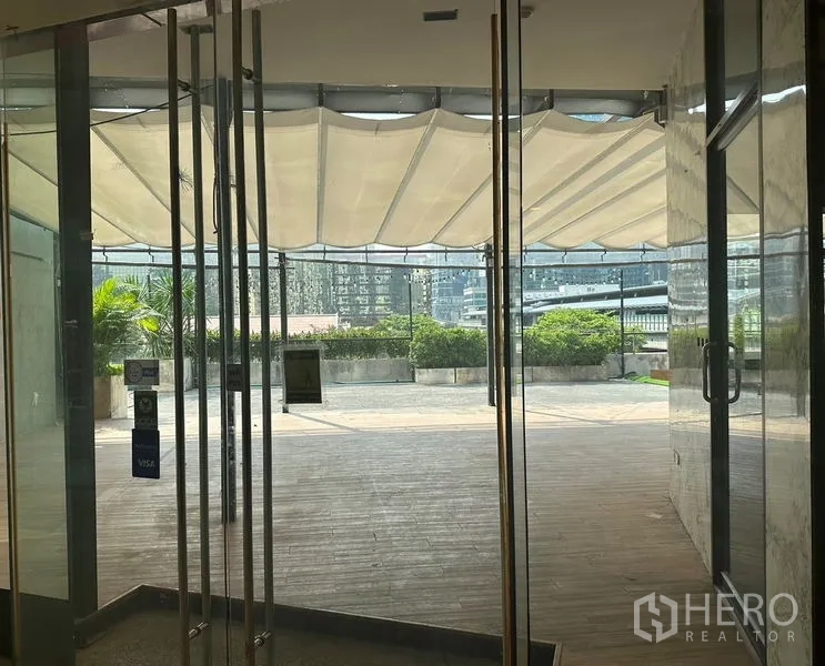 Retail Space for rent in Pathum Wan, Bangkok - View from glass doors to a landscaped plaza and canopy-shaded patio area.