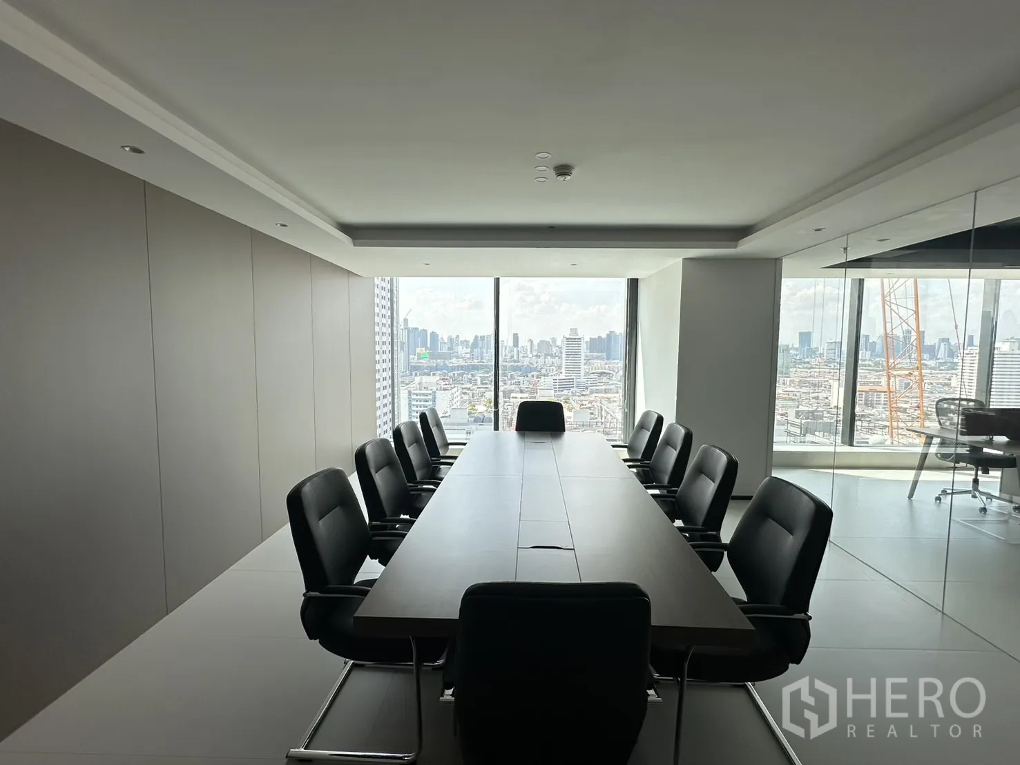 Office Space for rent in Din Daeng, Bangkok - Conference room with a long boardroom table and black chairs facing a city view.