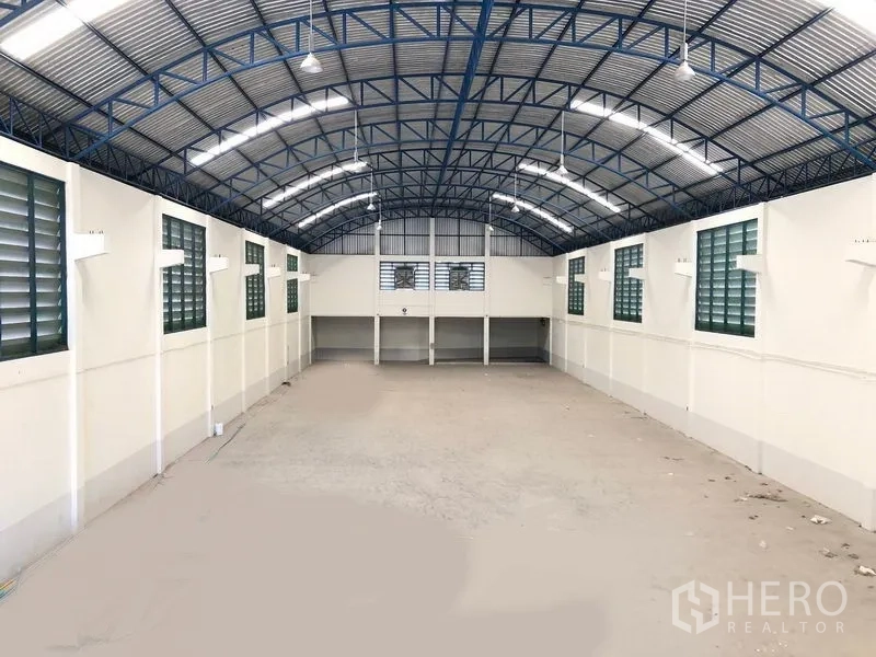 Factory for rent in Samut Prakan - Long clear-span production hall with louvered side windows, LED lights and smooth concrete floor.