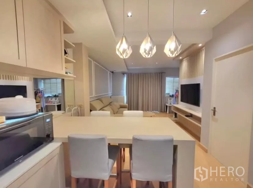 Townhouse for rent in Bang Phli, Samut Prakan - Kitchen island with pendant lights and breakfast bar facing the cozy living area.