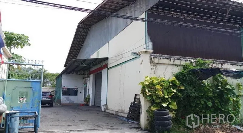 Warehouse for rent in Bang Phli, Samut Prakan - Warehouse exterior with roller shutter, covered loading bay and driveway.